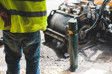 Fototapeta premium Process of asphalting, blacktopping and paving, asphalt paver machine and steam roller compactor during construction and repairing works, workers on the construction site, rental vehicle working