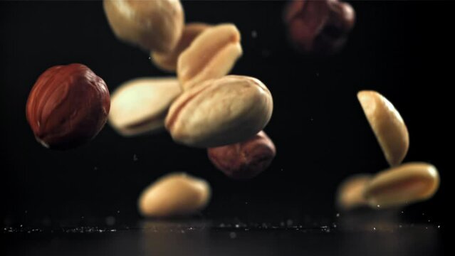 A variety of nuts fall on the table. Filmed on a high-speed camera at 1000 fps. High quality FullHD footage