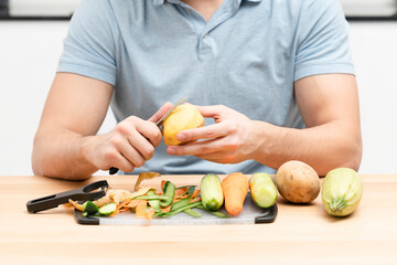 Close-up shot of a man peeling vegetables using special vegetable peelers in the kitchen