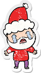 distressed sticker cartoon of a bearded man crying wearing santa hat