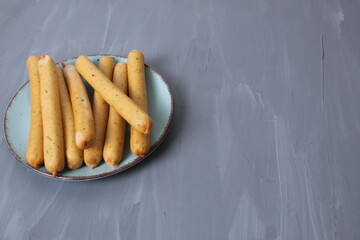 Natural chicken sausages lie in a plate on a gray copyspace background. Meat Day: Vegetarianism