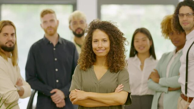 Woman leading a group of coworkers standing proud