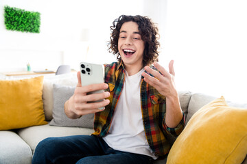 Photo of excited funky guy dressed checkered shirt communicating apple iphone samsung modern gadget...