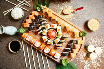 Fototapeta na wymiar Wooden Tray Topped With Sushi and Chopsticks