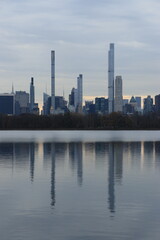 Fototapeta na wymiar New York City skyline from Central Park Lake with reflection in the water