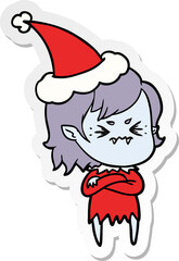 annoyed sticker cartoon of a vampire girl wearing santa hat