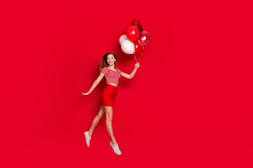 Full length photo of sweet pretty lady dressed striped top enjoying birthday party flying balloons empty space isolated red color background - obrazy, fototapety, plakaty