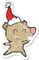 female bear distressed sticker cartoon of a wearing santa hat