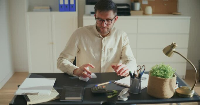 Entrepreneur crumbling paper at desk in office
