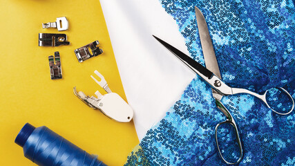 Sewing accessories. Clothes designer work desk. scissors, thread, blue textile, satin or silk...