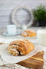 Traditional finnish cinnamon and cardamon rolls, korvapuusti. Home made buns with milk for breakfast. Hight key. 