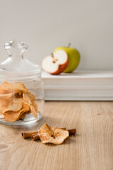 Dried apple slices on a wooden table in a glass jar