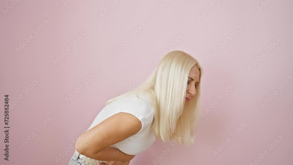 Poster Young blonde woman standing over pink isolated background, doubling over in pain as stomachache intensifies. hand on belly, suffering painful disease with nauseating cramps.