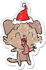 distressed sticker cartoon of a panting dog wearing santa hat