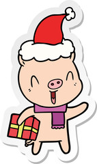 happy sticker cartoon of a pig with xmas present wearing santa hat