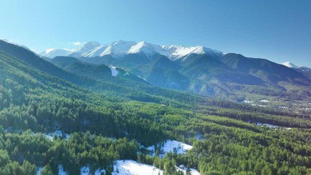 Drone flies sideways over mountain wilderness in Pirin Region, winter shot.