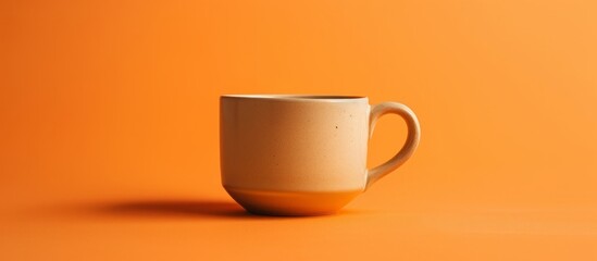 Tan coffee cup photographed on orange background