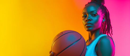 Confident African American female athlete , holding basketball in neon light