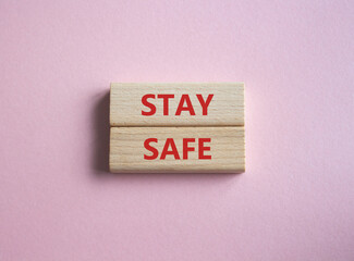 Stay Safe symbol. Concept word Stay Safe on wooden blocks. Beautiful pink background. Business and Stay Safe concept. Copy space