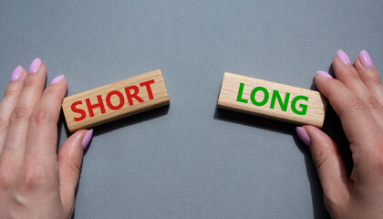 Short vs Long symbol. Concept word Short vs Long on wooden blocks. Businessman hand. Beautiful grey...