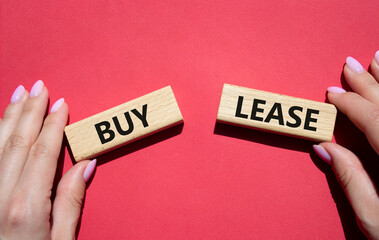 Buy or Lease symbol. Concept word Buy or Lease on wooden blocks. Businessman hand. Beautiful red background. Business and Buy or Lease concept. Copy space