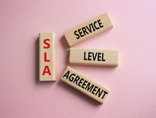 SLA - Service Level Agreement. Wooden blocks with word SLA. Beautiful pink background. Business and Service Level Agreement concept. Copy space.