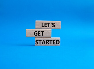 Lets get started symbol. Concept words Lets get started on wooden blocks. Beautiful blue background. Business and Lets get started concept. Copy space.