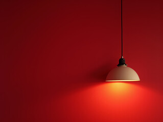 A lamp hangs against a red wall, casting its light and illuminating the area, with space available for text or presentation.