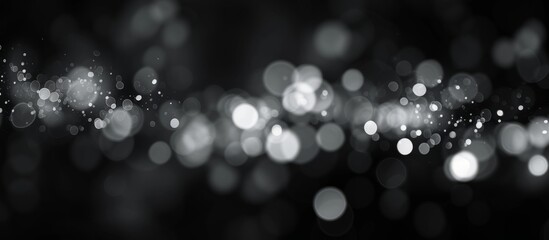 Blurred bokeh background with abstract white light on black, creating a pattern texture.