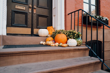 Thanksgiving pumpkin decorations on a stoop of a house in Manhattan, New York, USA.