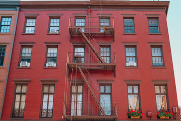 Obraz premium Red brick New York apartment block with fire escape at the front in Greenwich Village, New York, USA.