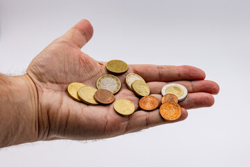 Money in the form of euro coins slips through the fingers during the crisis and inflation