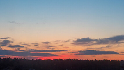 Fototapeta premium Sunset sky and sun through the clouds over. Golden sunset with blue colors. 