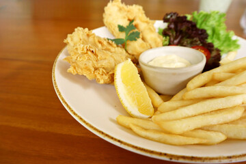 Traditional british fish and chips with tartar sauce, lemon slice and vegetable