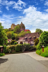 Fototapeta na wymiar Anblick der Burg Hohenstein mit alten Fachwerkhäusern in Mittelfranken, Bayern, Deutschland vor weiß-blauem Himmel
