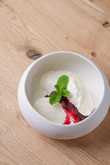 Creamy ice cream with jam in a deep white bowl