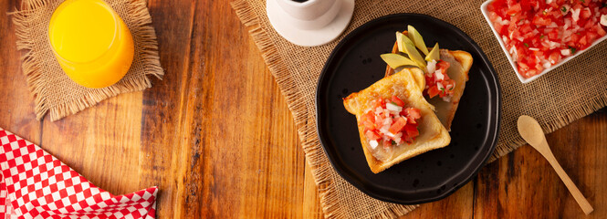 Breakfast toast with refried beans, avocado, melted cheese and mexican pico de gallo sauce. Easy and healthy homemade recipe that can be made in the oven, frying pan or air fryer.