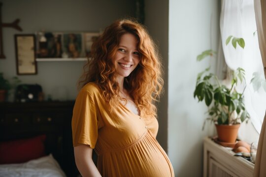 Smiling portrait of a young pregnant woman at home