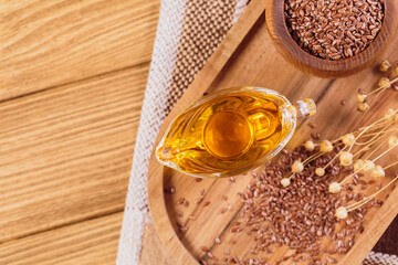 Brown linen seeds, flaxseed vegetable oil on wooden background