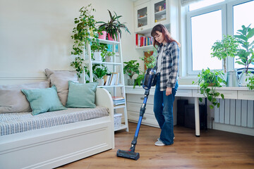 Young teenage female doing vacuuming at home