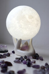 Amethyst crystals and moon in ceramic hand.
