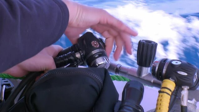 Hands of diver prepare diving aqualung for diving on yacht. Aqualung is an element of professional diving equipment.