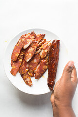 Top view of sliced chinese sausage, overhead view of sliced lap cheong sausage on white background