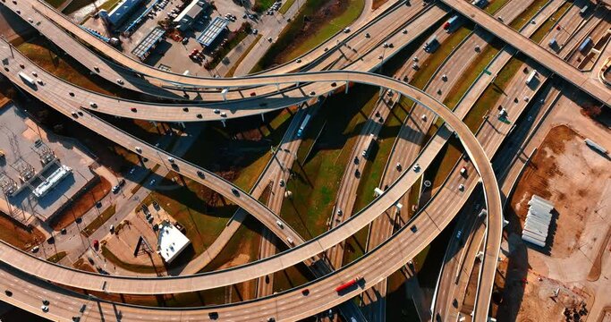 Cars move by the roads and freeways in Dallas, Texas, USA. Top view of the highways on sunny daytime.