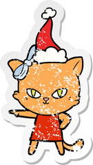 cute distressed sticker cartoon of a cat wearing dress wearing santa hat