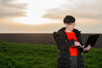 A woman agronomist examines planted young wheat