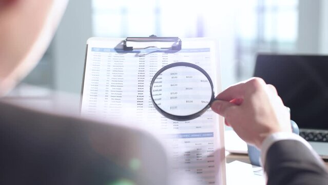 A document verification, magnifying glass, important report