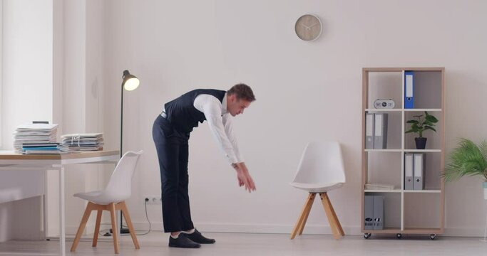 During a work break in the office, a businessman or accountant prioritizes health by incorporating exercise. He engages in a routine that includes stretching, warm up, and relaxation exercises.