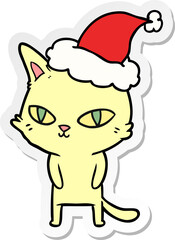 sticker cartoon of a cat with bright eyes wearing santa hat