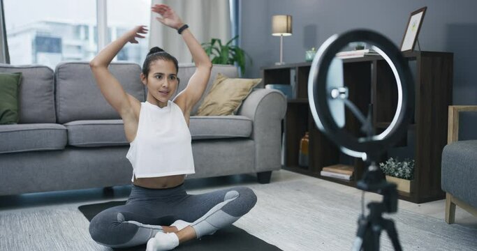 Yoga, stretching and phone recording woman, social media influencer or vlogger streaming exercise tutorial. Ring light, virtual personal trainer and broadcast warm up for home fitness on smartphone